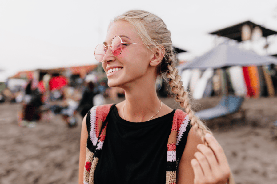 Blond vrouw roze zonnebril festival vlecht lach